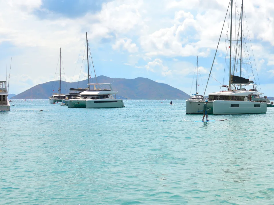 Anchored sailing catamarans and turquoise coastal water off Tortola, British Virgin Islands