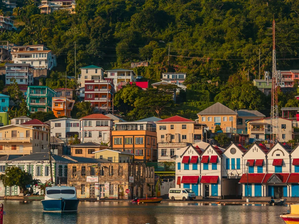 Colourful waterfront buildings and a green hillside above harbour water in Saint George's, Grenada