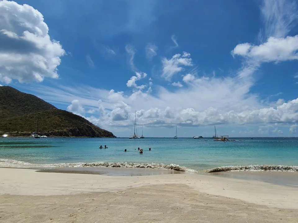 Sandy Anse Marcel beach and anchored sailboats between hilly headlands in the French part of Saint Martin