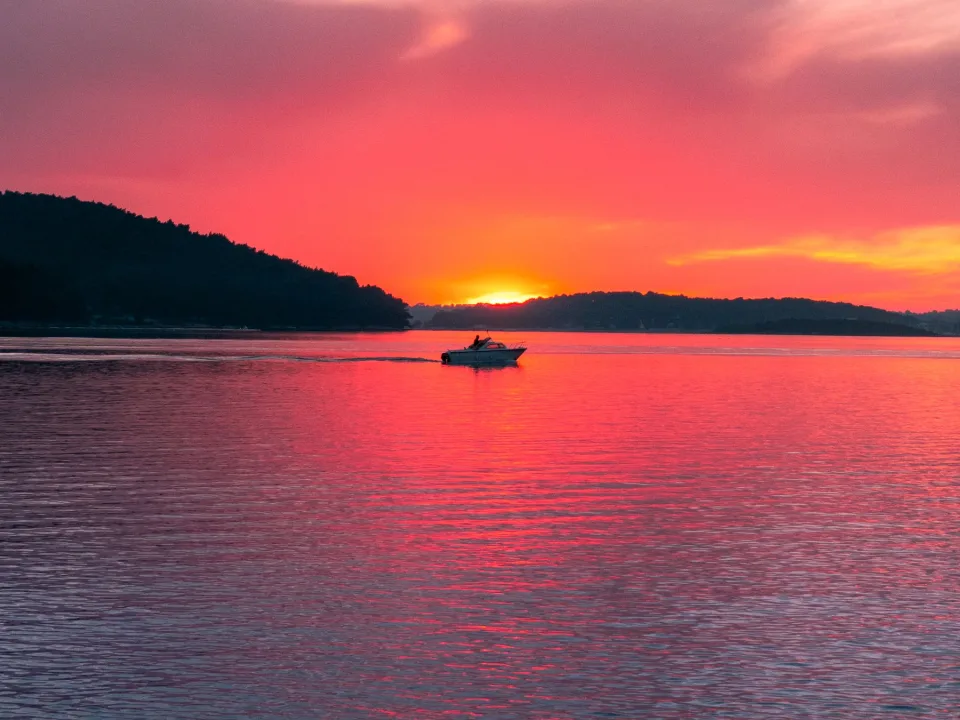 A boat silhouetted against the evening sky over Medulin Bay.