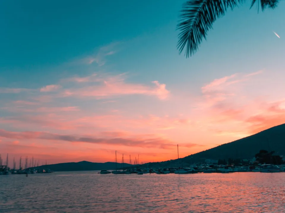 Sailboat masts along the Dalmatian coast at sunset.