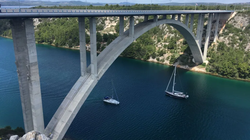 Boats on the river near Skradin beneath an arched bridge.