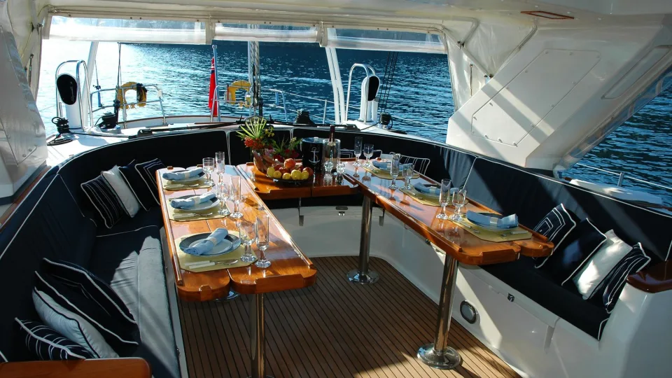 A dining table and seating on a yacht deck.