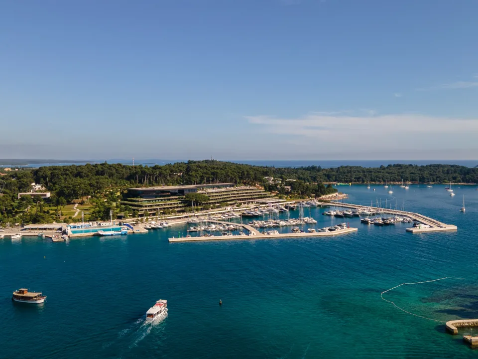 Aerial view of a marina and wooded shoreline near Rovinj.