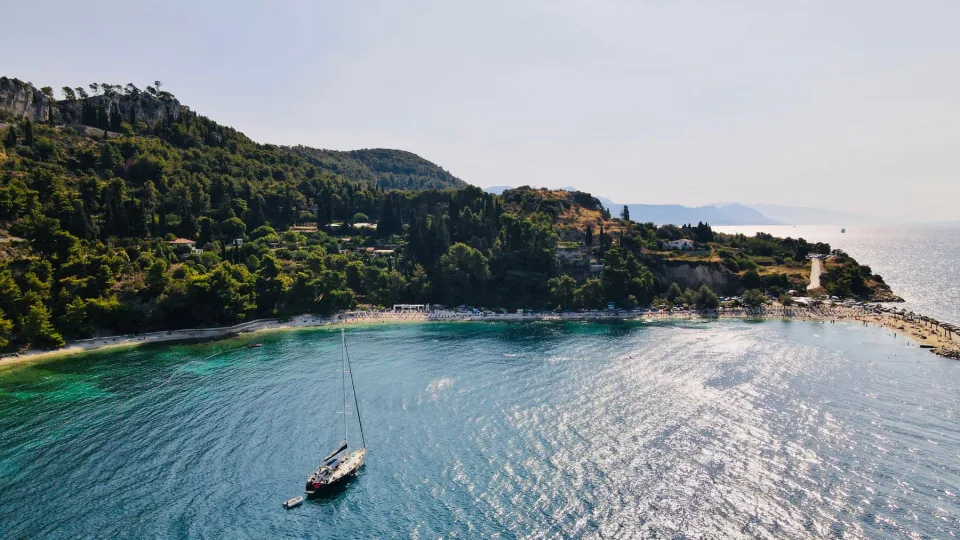 A sailboat beside a wooded coast in Split-Dalmatia.