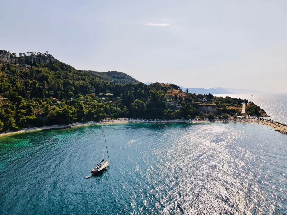 A sailboat beside a wooded coast in Split-Dalmatia.