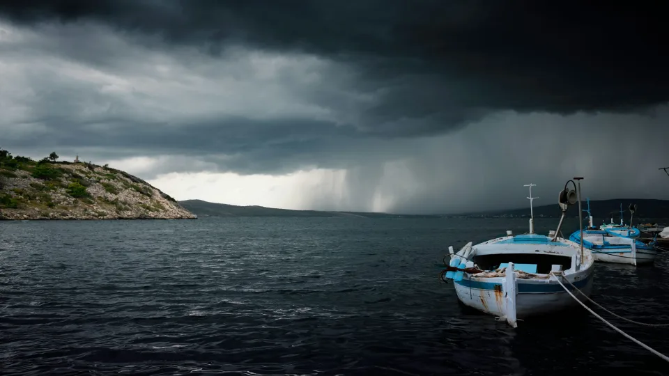 Small boats on the Novigrad Dalmatia waterfront beneath storm clouds