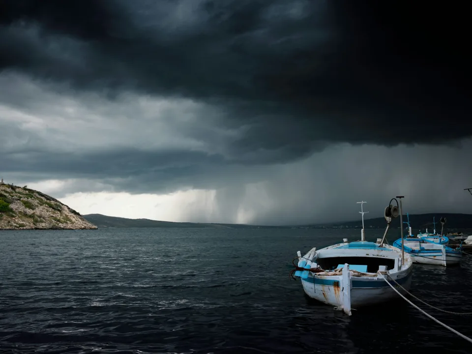 Small boats on the Novigrad Dalmatia waterfront beneath storm clouds