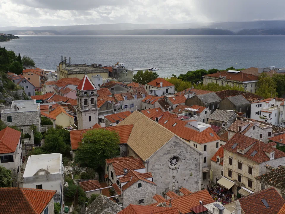 Omiš rooftops and church tower with the sea beyond
