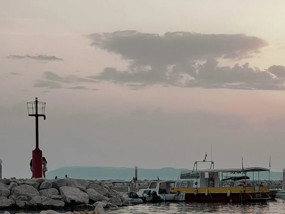 Regional sunset view of the harbour beacon and boats at Tučepi