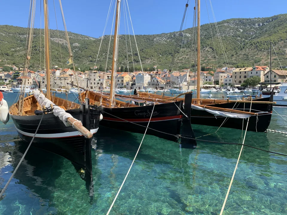 Regional view of wooden boats and clear harbour water on Vis island