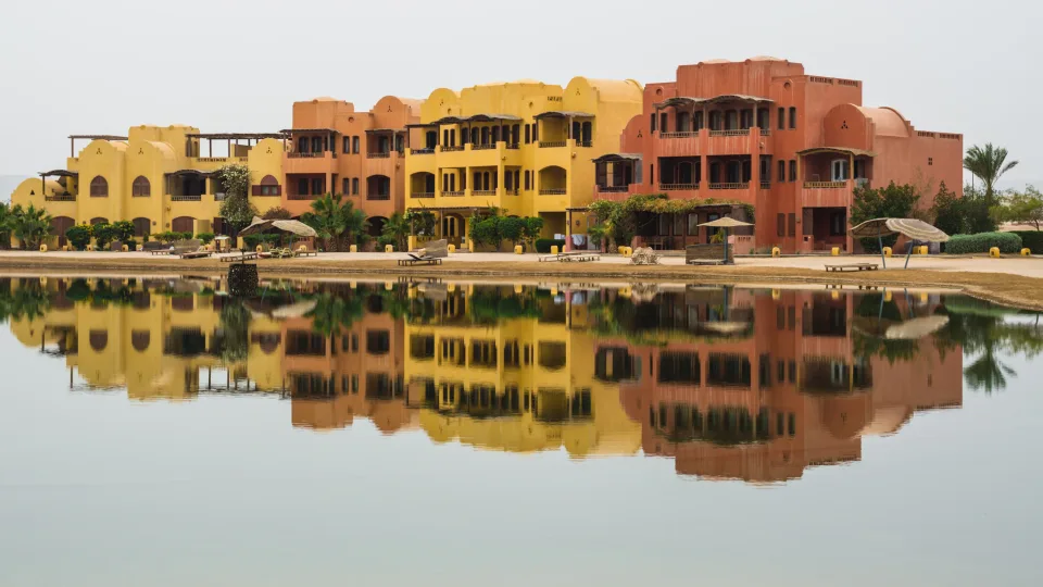 Colourful waterfront buildings reflected in water at El Gouna
