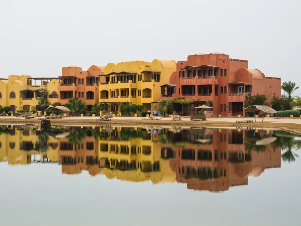 Colourful waterfront buildings reflected in water at El Gouna