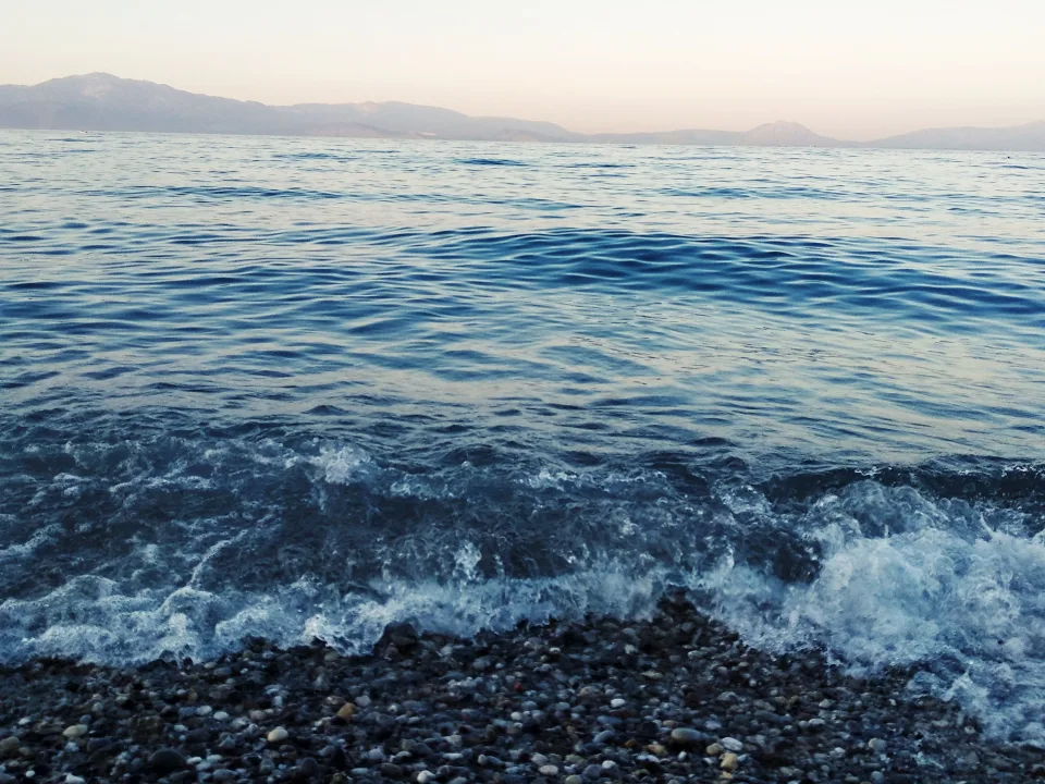 Waves reaching a pebbly beach at Kiato