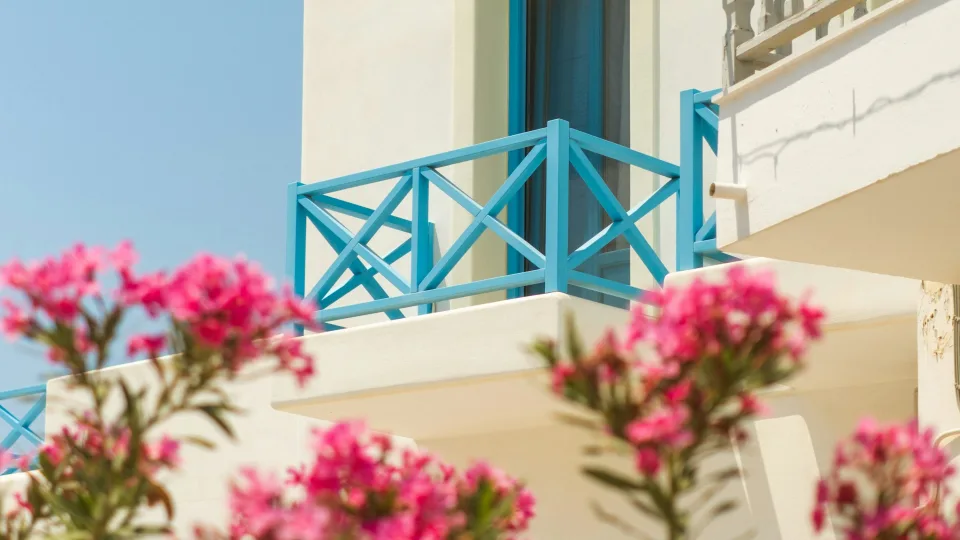 White house with blue balcony and pink flowers in Naoussa on Paros