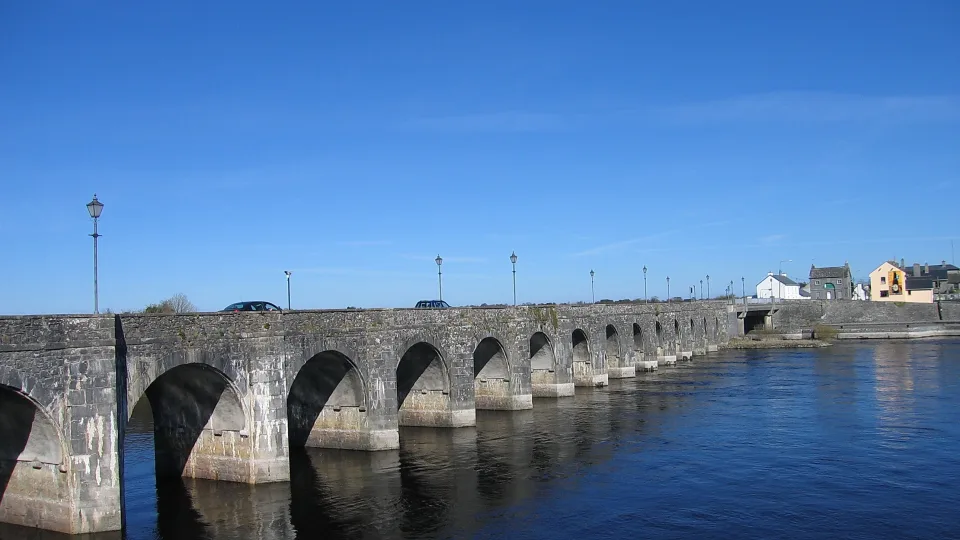 Regional river context: stone arches of Shannonbridge over the River Shannon, with water and far-bank houses