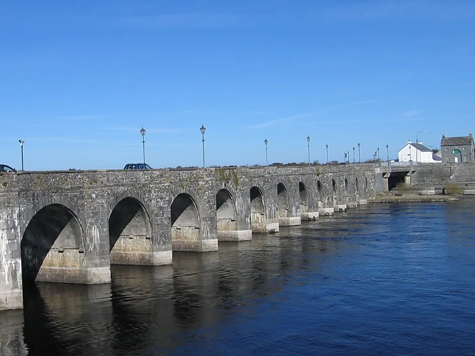Regional river context: stone arches of Shannonbridge over the River Shannon, with water and far-bank houses