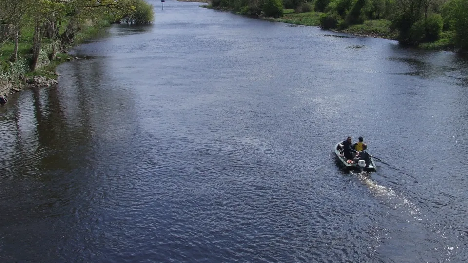 The River Shannon at Drumsna, with a river bend, wooded banks and a small fishing dinghy