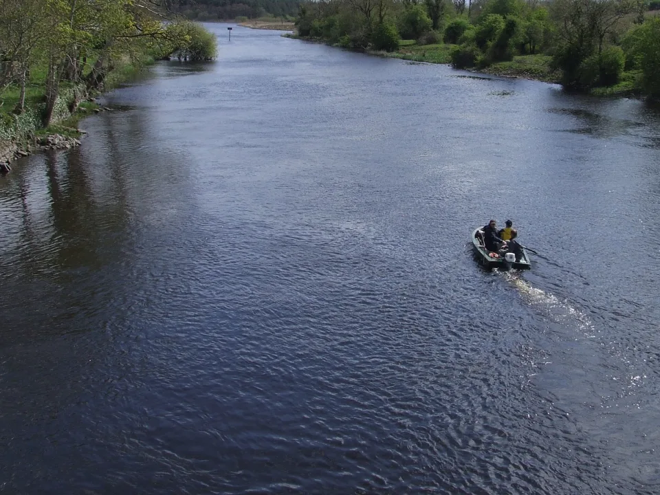 The River Shannon at Drumsna, with a river bend, wooded banks and a small fishing dinghy