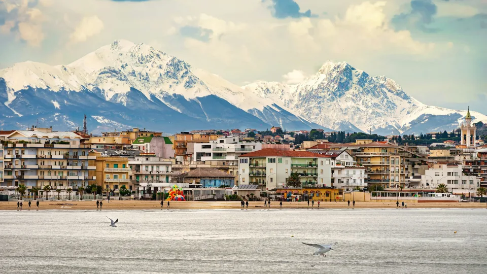 Pescara waterfront with snow-covered mountains beyond