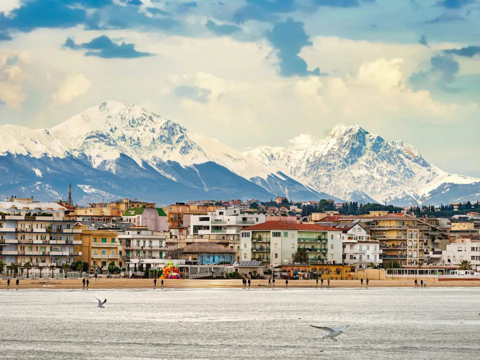 Pescara waterfront with snow-covered mountains beyond