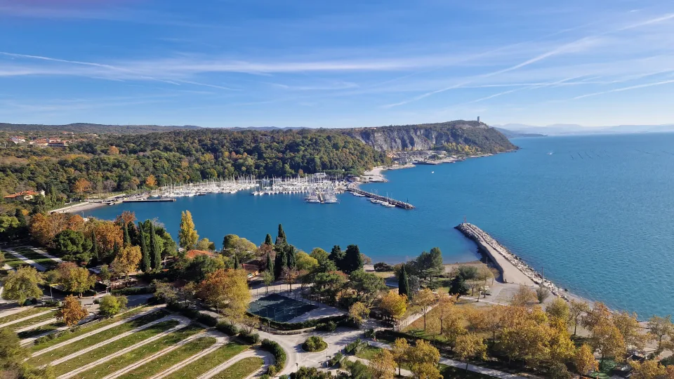 Sistiana Bay with boats and the wooded coastline