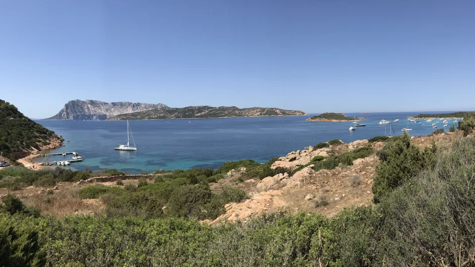 Regional coastal context: Capo Coda Cavallo in the municipality of San Teodoro, with boats and nearby islands
