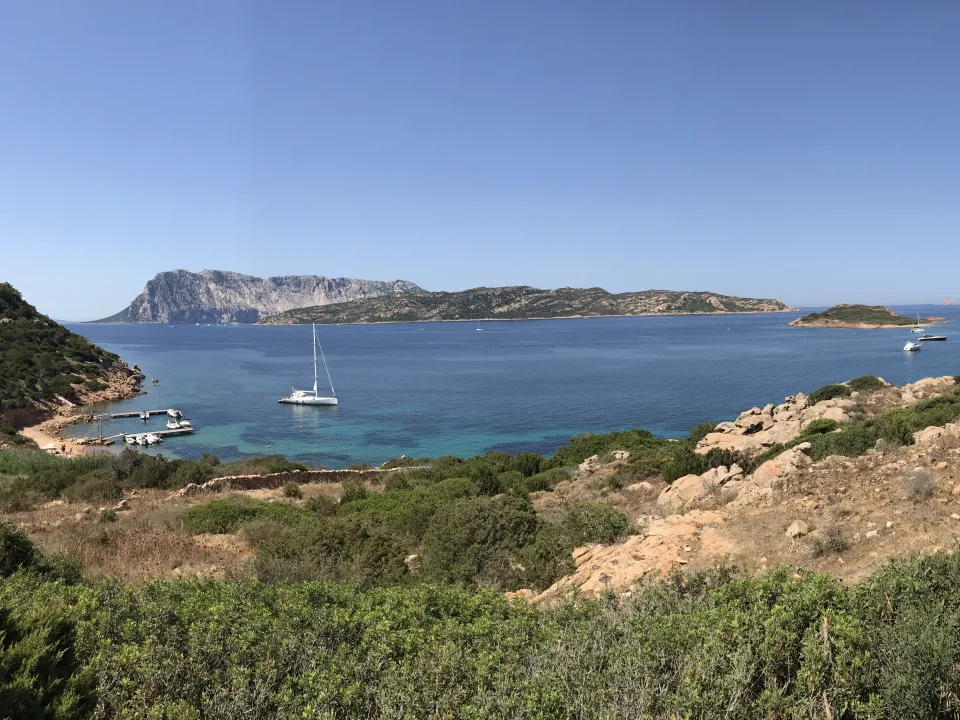 Regional coastal context: Capo Coda Cavallo in the municipality of San Teodoro, with boats and nearby islands