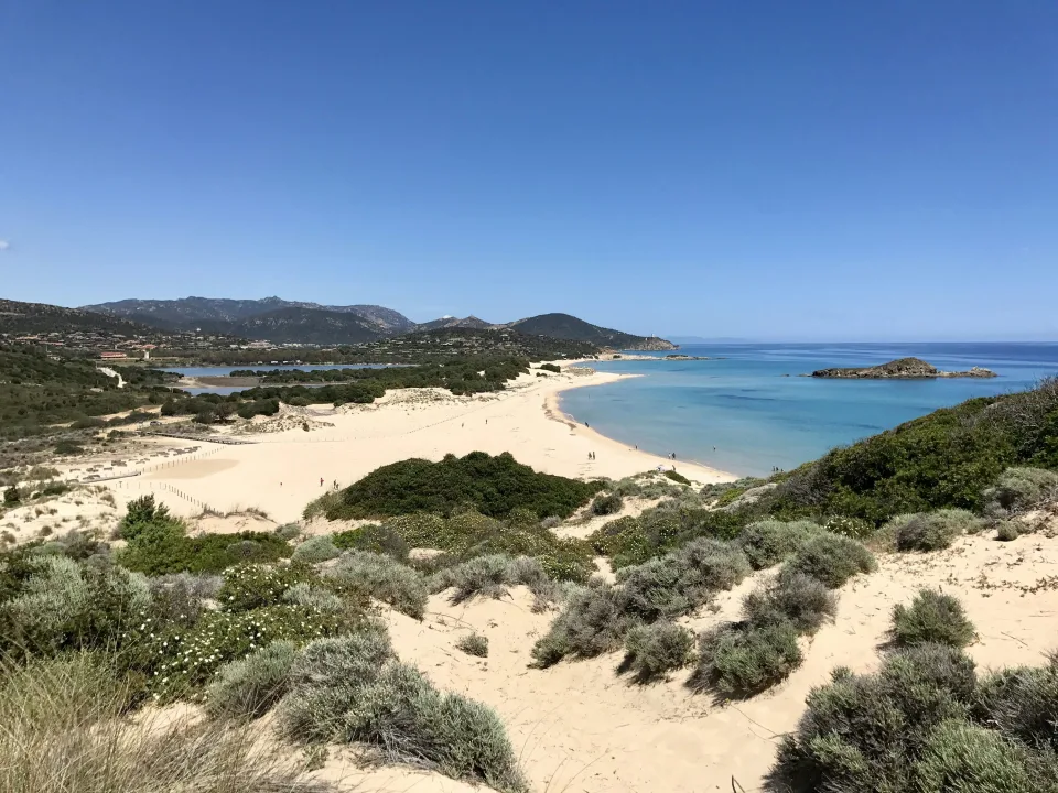 Regional coastal context: pale sand, dunes and turquoise water at Chia in southern Sardinia