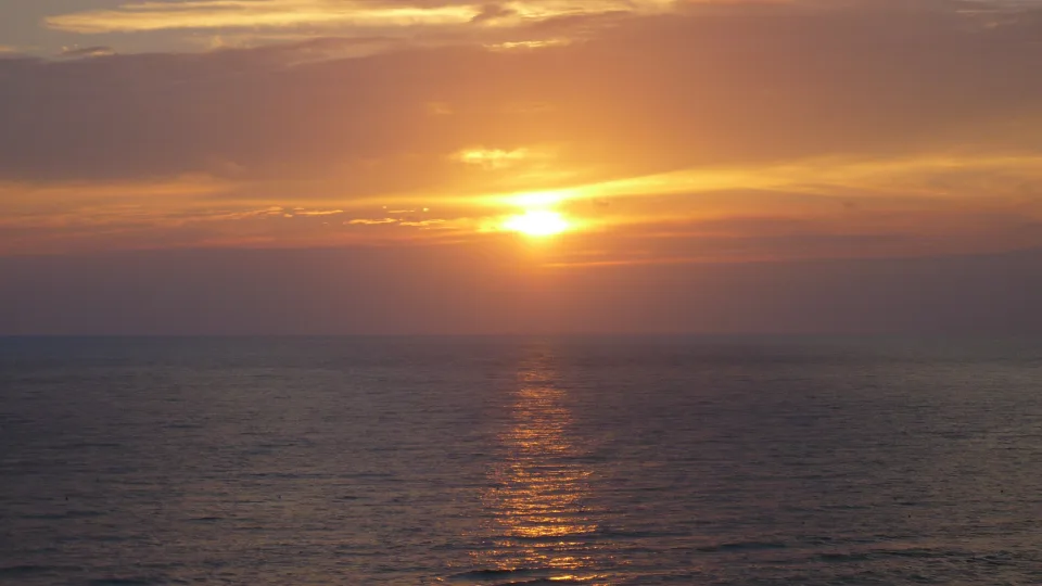 Sunset over the sea at Anzio with warm light reflected on the water
