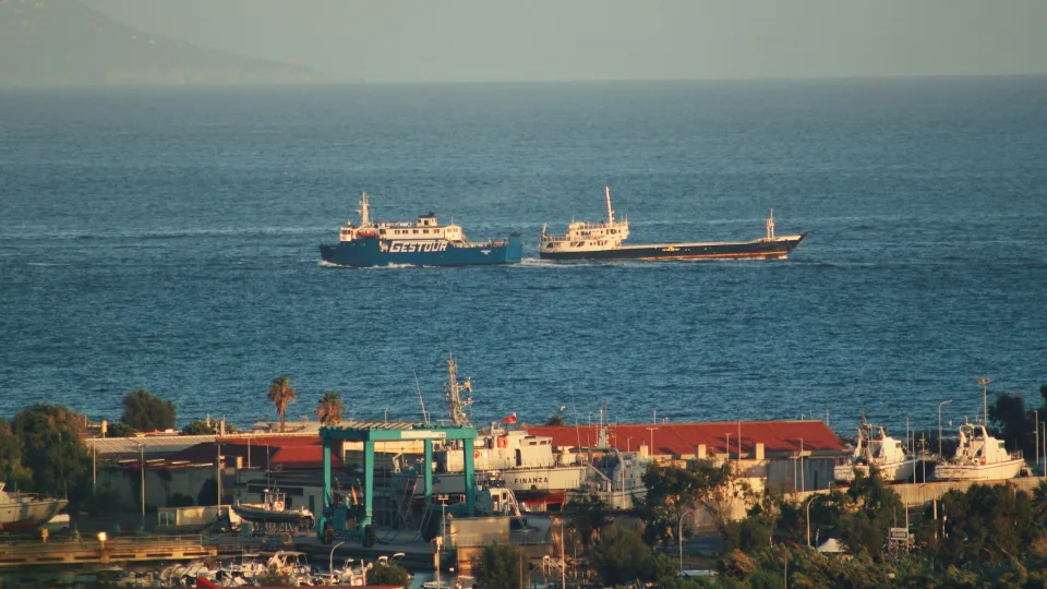 Coastal view at Bacoli with vessels offshore and a boatyard in the foreground