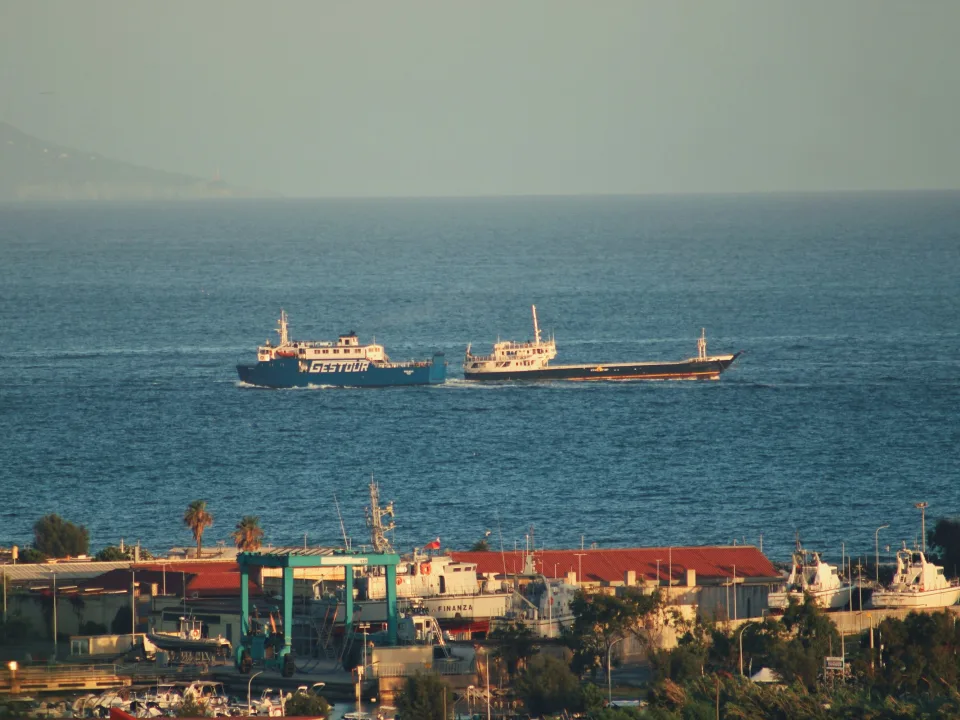 Coastal view at Bacoli with vessels offshore and a boatyard in the foreground