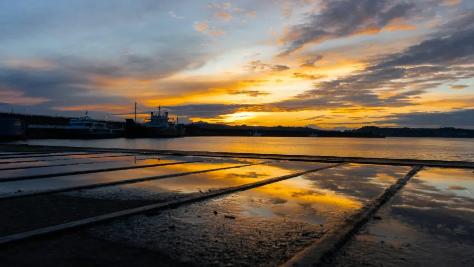 Sunset reflected on a wet quay at the port of Pozzuoli