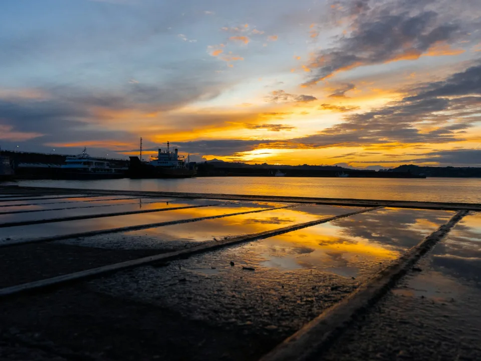 Sunset reflected on a wet quay at the port of Pozzuoli