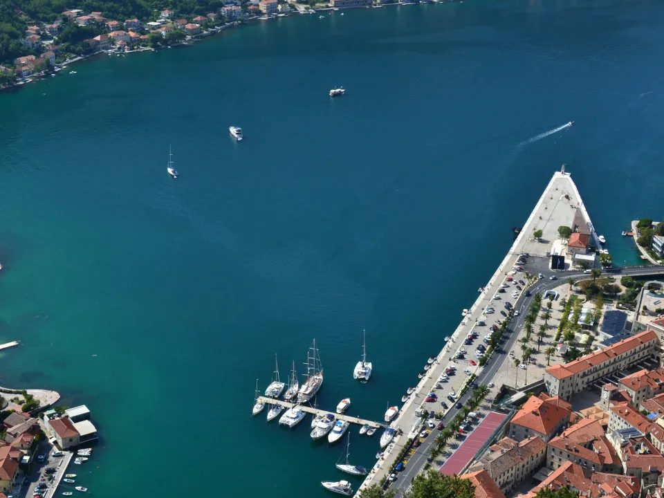 Aerial view of Kotor bay with waterfront buildings and moored boats