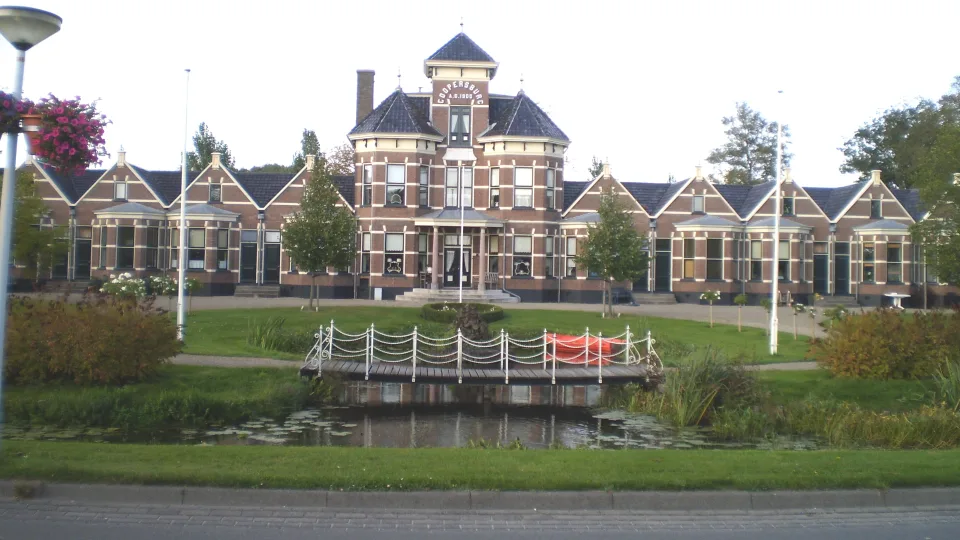Historic Coopersburg building and garden pond in Akkrum