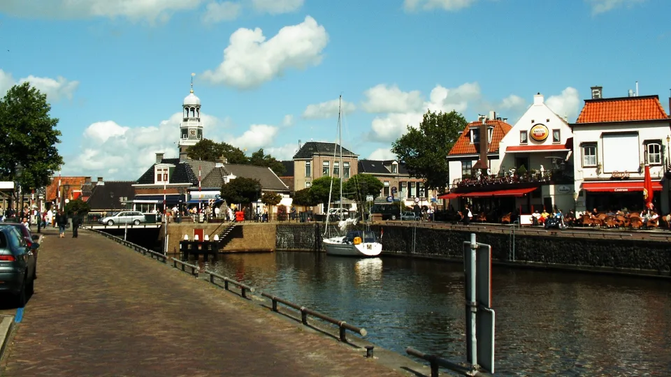 Sailboat and waterfront buildings beside Lemmer harbour