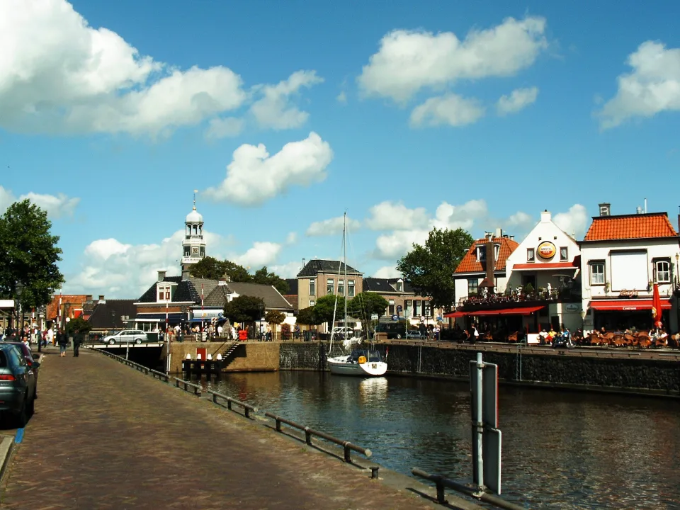 Sailboat and waterfront buildings beside Lemmer harbour in the Netherlands