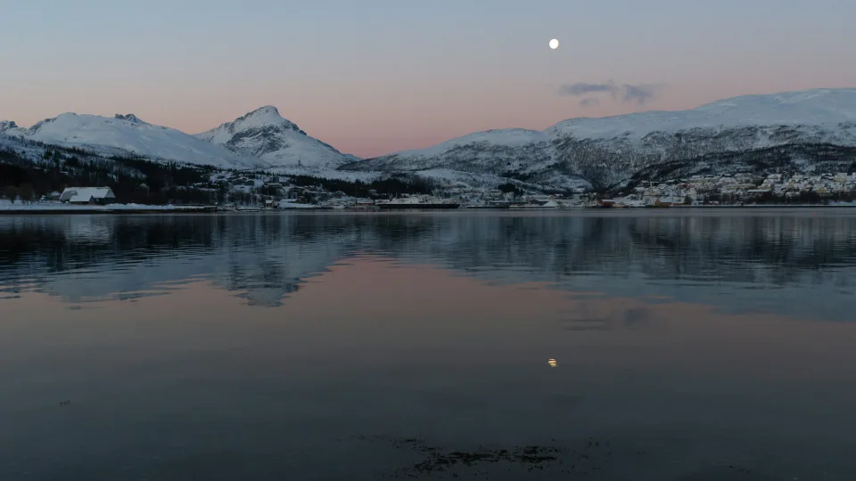 Regional Kvaløya coastal landscape with snowy mountains and moon, Norway