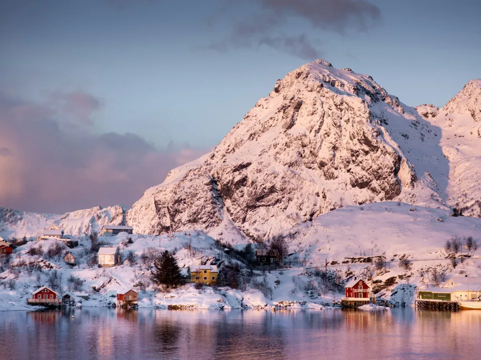 Snow-covered village and coastal mountains at Moskenes, Norway