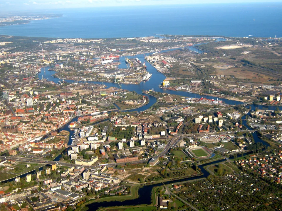 Historical aerial view of Gdańsk city and harbour waterways with the coast beyond