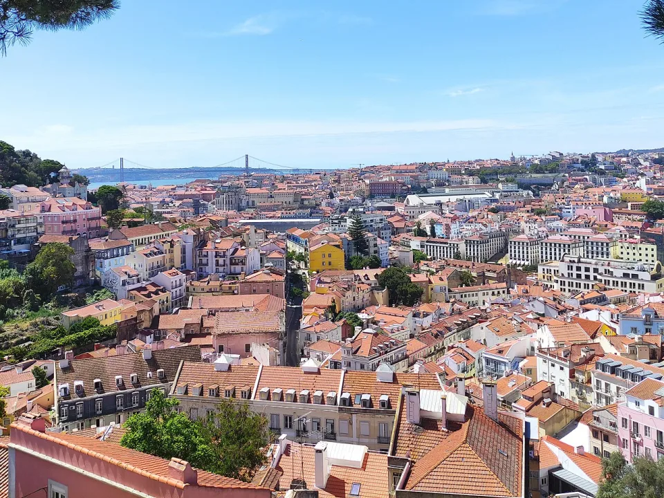 Lisbon rooftops, the Tagus and a distant bridge viewed from Miradouro da Graça
