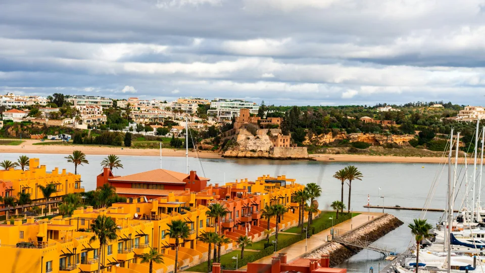 Colourful waterfront buildings, river water and yacht masts in Portimão, Portugal