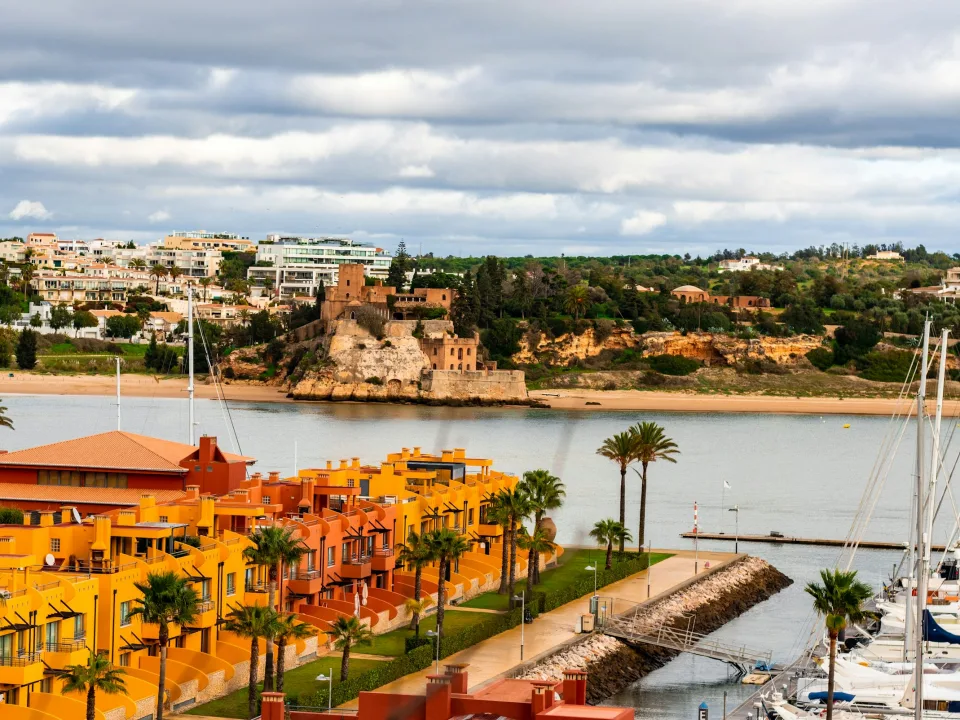 Colourful waterfront buildings, river water and yacht masts in Portimão, Portugal