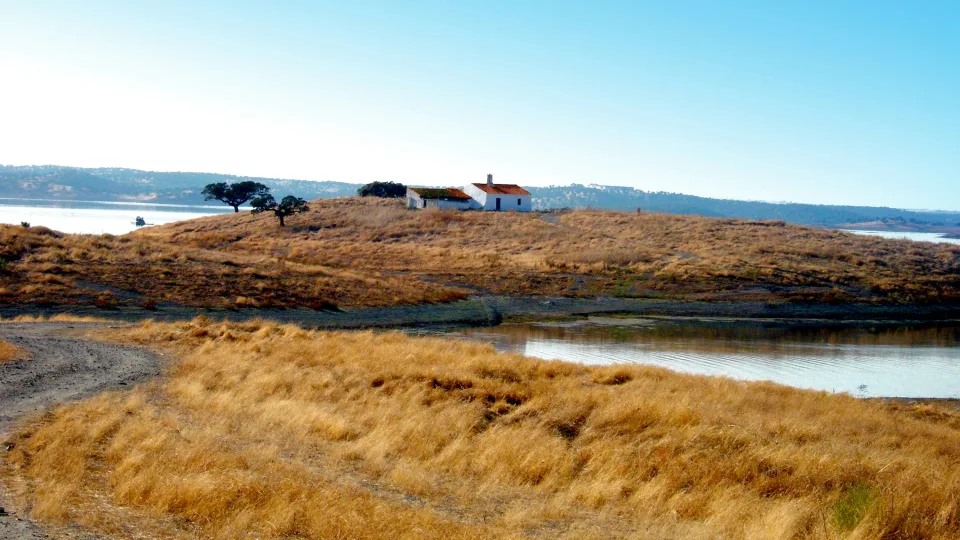 Regional scenery: White house on a dry grassy peninsula beside Alqueva reservoir in Portugal