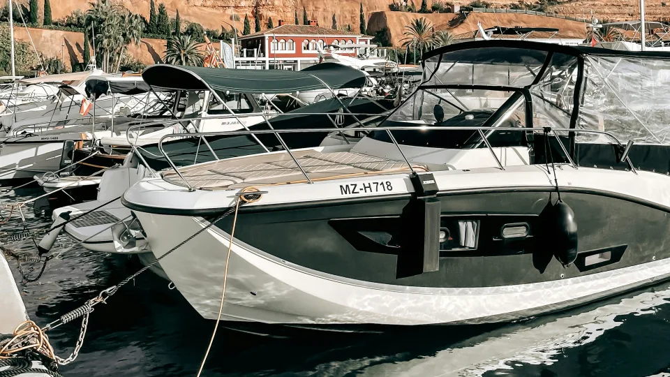 Moored boats and the cliffs above Port Adriano, Mallorca, Spain