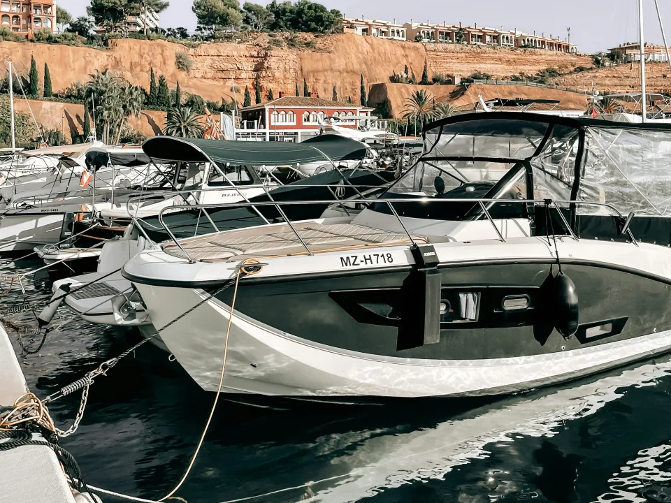 Moored boats and the cliffs above Port Adriano, Mallorca, Spain