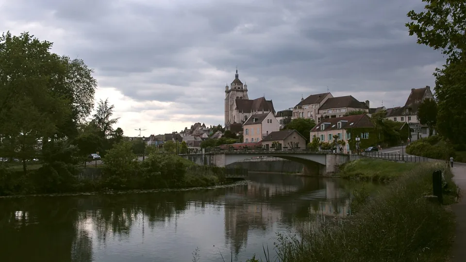 Dole and its waterside buildings reflected in the Canal du Rhône au Rhin.