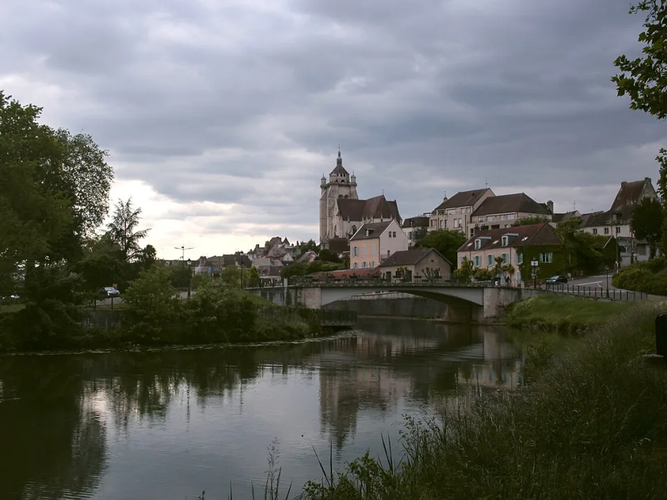 Dole and its waterside buildings reflected in the Canal du Rhône au Rhin.