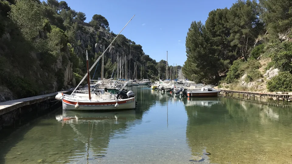 Sailing boats moored between the wooded rocky banks of Port-Miou, Cassis.